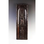 A carved oak hanging wall plaque, 19th century, the heavily carved frame enclosing an arched
