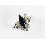 A sapphire and diamond cluster ring, the central marquise shaped sapphire measuring 12mm x 4mm,