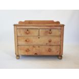 A Victorian pine chest of two short and two long drawers, applied with knob handles, raised upon