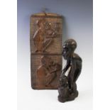 A West African carved tribal plaque, depicting two men modelled seated smoking opium and drinking,