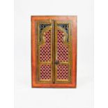 A painted Indian hardwood hanging corner cupboard, the openwork carved doors enclosing a vacant