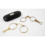 A pair of gilt metal lorgnette glasses, early 20th century, in associated case, with a further