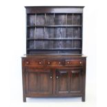 A late 18th century oak welsh dresser, the high back with a plain frieze above three enclosed