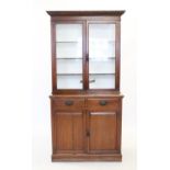 An Edwardian walnut glazed library bookcase,with a moulded cornice above a pair of glazed doors