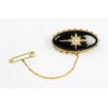 A Victorian seed pearl set mourning brooch, the lozenge shaped brooch surmounted by a starburst