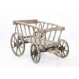 A late 19th century beech and pine dog cart, the slatted cart raised upon eight spoke 37cm rear