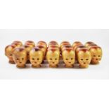 A collection of twenty six composition dolls heads, with painted eyes and mouth, 12cm high (26)