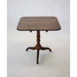 A George III oak tilt top tripod table, the square top with rounded corners, raised upon a ring
