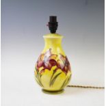 A Moorcroft table lamp of baluster form, decorated with lily's against a yellow ground, 30cm high