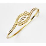 A diamond and pearl set hinged bangle, the three central mine cut diamonds claw set to a twist