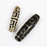 Two Tibetan Dzi beads, 7cm and 6cm long (2)