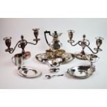 A collection of silver-plated wares, to include a pair of candelabra, with central acorn finials,