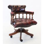 An oak framed blood red leather upholstered captains chair, late 20th century, with a button back