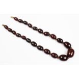 A cherry amber bead necklace, the single strand necklace comprising twenty-two graduated cherry