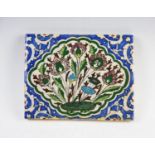 A Persian Iznik hand painted glazed fritware tile, circa 17th century, the central medallion with