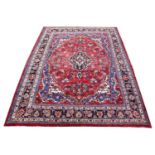 A washed red ground Persian sarouk carpet, with traditional medallion design, 310cm x 225cm