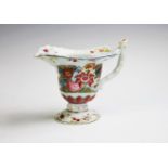 A Chinese porcelain tobacco leaf ewer, 18th Century, of typical helmet shape rising from a