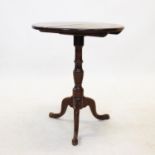 A George III oak tripod table, the circular top supported upon a ring turned baluster shaft, three