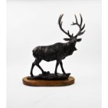 A patinated bronze model of a stag mounted on a lozenge shaped wooden plinth, 48cm high