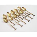 A set of eleven continental silver gilt teaspoons, the bowls designed as leaves, the handles of twig