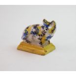 A 20th century faience cat novelty inkwell, decorated in a blue, yellow and brown sponge glaze, to a