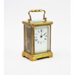 An early 20th century lacquered brass carriage timepiece, with a 6cm white enamel dial, Roman