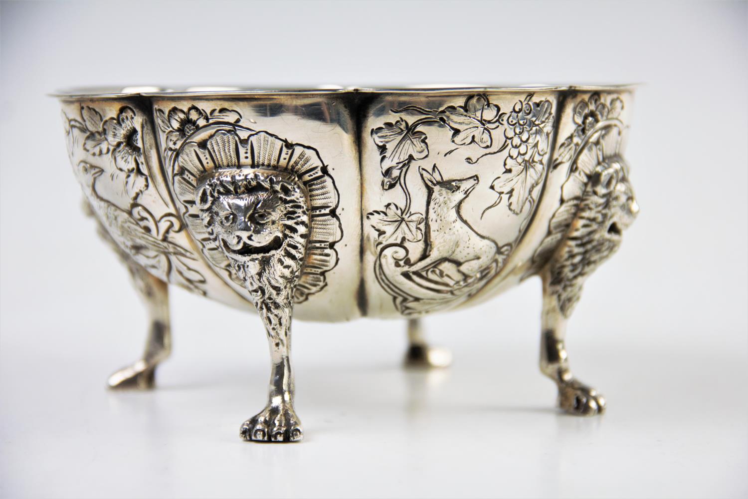 A continental white metal bowl, the floral form bowl, with eight defined panels, decorated with a