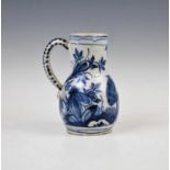 An 18th century Delft blue and white jug, externally decorated with a central peacock perched upon a