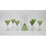 Six Bohemian green glass wine glasses and and a larger similar wine glass, with a glass lemonade jug