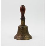 A military issue hand bell, with turned hard wood handle, cast in relief with a broad arrow head,