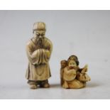 A late 19th century Japanese carved ivory netsuke, depicting a seated mother, flanked by a child,