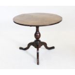 A George III oak tripod table, the circular cross banded top raised upon a baluster shaft and