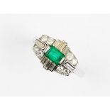 A diamond and emerald 18ct white gold cluster ring, the oblong shaped head comprising a