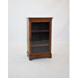 An Edwardian oak music cabinet, the rectangular moulded top above a single glazed door, enclosing