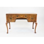 A George II style walnut side table, the shaped and cross banded top with a leaf carved border above