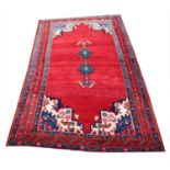 A red ground Persian Sarouk village rug with an unusual central medallion design, 225cm x 125cm