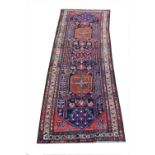 A deep blue ground old Caucasian runner with all-over medallion design, 290cm x 100cm