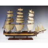 A wooden model of the tea clipper Cutty Sark in full sail, with stained and varnished hull, brass