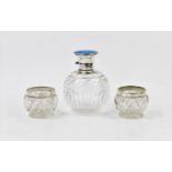 An early 20th century silver topped scent bottle, the hinged cover with blue guilloche enamel top,