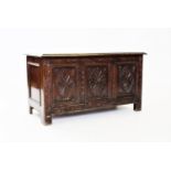 A 17th century style oak coffer, 20th century, with three carved panels, raised upon stile feet,