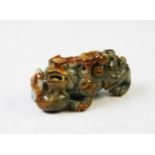 A Chinese carved spinach and mutton jade Dog of Fo, 10cm long