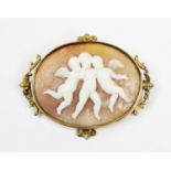 A carved shall cameo brooch, the oval form cameo with three winged putti to centre, set to an