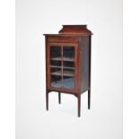 An Edwardian music cabinet, with a single glazed door, raised upon legs of tapering square