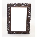 A late 19th century oak mirror from the Macclesfield school of carving, the rectangular bevelled