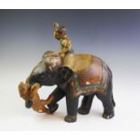 An Indian carved wood and painted figural group, early 20th century, modelled depicting a tiger