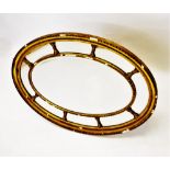 A Regency gilt wood and gesso oval wall mirror, the central oval bevelled mirrored plate enclosed by