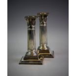 A pair of Victorian silver candlesticks, London 1890, each designed as columns with a composite