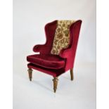 A 19th century gilt wood and gesso wing back armchair, the shaped and padded wing backs applied with