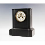 A Victorian slate mantel clock with visible escapement, the plain rectangular case housing the