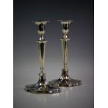 A pair of Edwardian silver candlesticks, Sheffield 1906, each modelled on a tapering base,